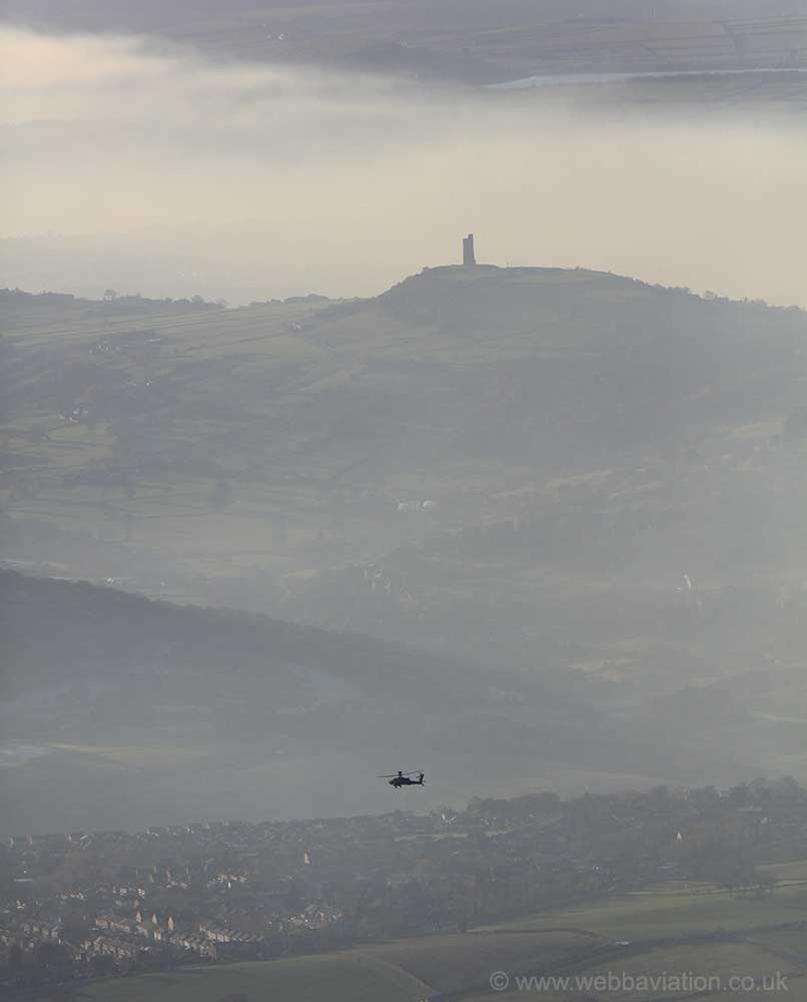 Military power over 2 millennium, an Apache attack helicopter flies over  Castle Hill Iron Age hill fort , Huddersfield 